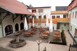 un patio con mesas, sillas y una fuente en Gasthaus Stöttnerbräu, en Vohburg an der Donau