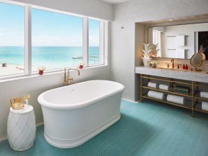 a bath tub sitting next to a white toilet at Faena Hotel Miami Beach in Miami Beach