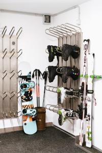 une chambre avec des skis et des snowboards suspendus sur un mur dans l'établissement Garni Fany, à Colfosco