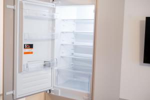un frigorifero vuoto con la porta aperta in una cucina di Central Tower Apartments a Suceava