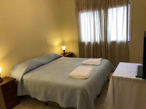 a bedroom with a bed with two towels on it at Departamento Salta Capital in Salta