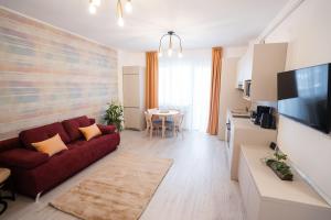 Una sala de estar con un sofá rojo y una cocina. en Central Tower Apartments, en Suceava