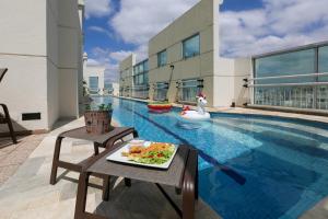 um prato de comida numa mesa ao lado de uma piscina em Quality Suítes Oscar Freire em São Paulo