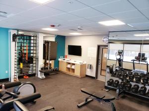 a gym with cardio equipment and a television in a room at Avid Hotels - Cincinnati N - West Chester by IHG in West Chester