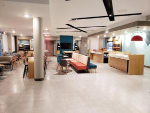 a lobby with chairs and tables in a building at Avid Hotels - Cincinnati N - West Chester, an IHG Hotel in West Chester