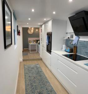 a kitchen with white counters and a tv on the wall at Blue Haven in Brighton & Hove