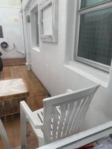 une chaise blanche assise devant une fenêtre dans l'établissement Blue Haven, à Brighton et Hove