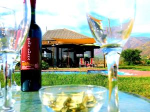 een tafel met wijnglazen en een fles wijn bij Encantador Loft, entre Viñas, Valles y Piscina Privada in Santa Cruz