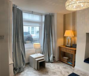 Zimmer mit einem Fenster und einem Tisch mit einer Lampe in der Unterkunft Blue Haven in Brighton & Hove + 13 Fotos