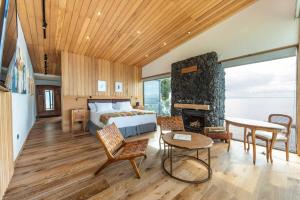 a bedroom with a bed and a room with a fireplace at Hotel AWA in Puerto Varas