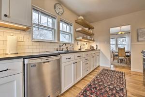 uma cozinha com armários brancos e uma máquina de lavar louça em aço inoxidável em Boise Tudor Home with Game Room Less Than 2 Mi to Downtown! em Boise