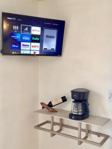 TV en la pared con cafetera en un estante en HOTEL COLIBRÍ en Creel