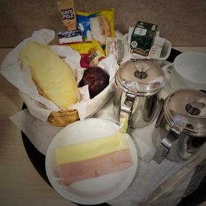 a table with a bowl of cheese and other food at Motel Monza (Adult Only) in Santos