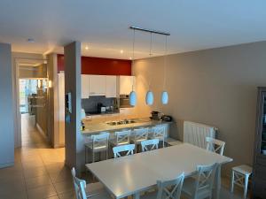 cocina con mesa blanca y sillas en appartement aan zee, en Blankenberge