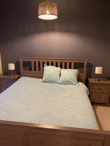 ein Schlafzimmer mit einem großen Bett mit zwei Nachttischen in der Unterkunft appartement aan zee in Blankenberge