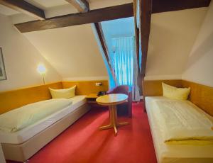 Habitación con 2 camas y mesa. en Meister BÄR HOTEL Ostbayern en Floß