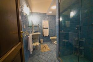 ein Badezimmer mit Dusche, Waschbecken und Toilette in der Unterkunft Residenza Golfo Degli Ulivi in Caprioli + 115 Fotos
