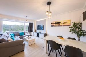 een woonkamer met een bank en een tafel bij Ostend Center Parkview Apartment Free Parking in Oostende