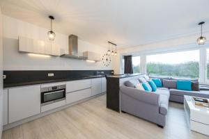 een keuken en een woonkamer met een bank en een tafel bij Ostend Center Parkview Apartment Free Parking in Oostende