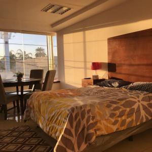 1 dormitorio con cama, mesa y comedor en Departamentos Bonsai en Torreón