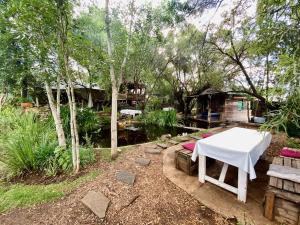 a table and benches in a yard with a house at Mizpah Lodge in Bloemfontein