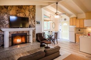a living room with a fireplace with a tv at Andril Fireplace Cottages in Pacific Grove