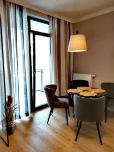 ein Esszimmer mit einem Tisch und Stühlen sowie einem großen Fenster in der Unterkunft Długie Ogrody Apartment 209 Gdańsk in Danzig