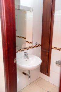 a bathroom with a sink and a mirror at Nobilis Standard Suite located in a wonderful location for a great experience in Kigali