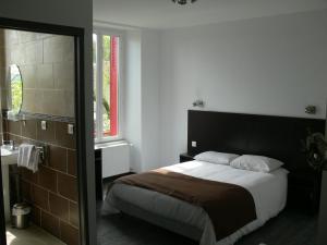 Un dormitorio con una cama grande y un baño. en Hotel Le Saint Julien, en Saint-Julien-du-Sault