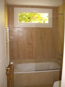 a bathroom with a bath tub with a window at Cul de Sac in Carilo +24 photos