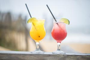 two cocktails sitting on top of a wooden rail at The Sea Ranch Resort in Kill Devil Hills