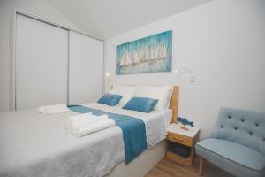 a bedroom with a bed and a blue chair at Salsa in Supetar