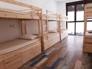 two bunk beds in a room with wooden floors at Hub Hostel Seville in Seville