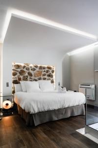 um quarto com uma cama grande e uma parede de pedra em Mirador del Alba em Ossa de Montiel