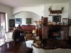 a woman sitting in a chair in a living room with a fireplace at Villa Sara Guesthouse in Sveti Stefan