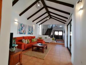 a living room with a red couch and a table at Casa La Florida in Tuineje