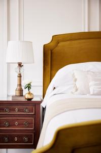 a bed with a lamp and a dresser at Kennebunkport Captains Collection in Kennebunkport