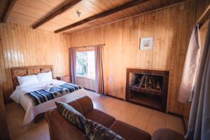 sypialnia z łóżkiem i kominkiem w obiekcie Cabañas Rancho Viejo w mieście El Pacífico