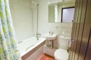 a bathroom with a toilet and a sink and a tub at Long Byres Holiday Cottages in Brampton +47 photos