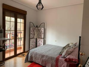 sypialnia z łóżkiem i dużym oknem w obiekcie Hoster cinema VERONA w mieście Tomelloso