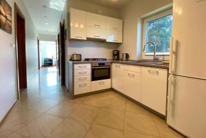 a kitchen with white cabinets and a refrigerator at Willa ala Maria in Świnoujście