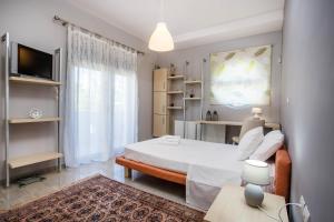 niewielka sypialnia z łóżkiem i telewizorem w obiekcie Villa de Manu w mieście Rodos