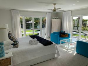 a bedroom with a large bed and a blue couch at Hahei Bed and Breakfast in Hahei