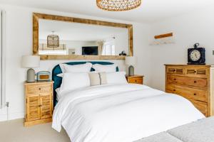 a bedroom with a large white bed and a mirror at The Gate Cornwall in Looe