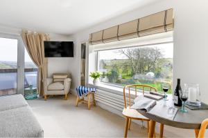 ein Wohnzimmer mit einem Tisch und einem Fenster in der Unterkunft The Gate Cornwall in Looe