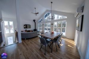 a dining room and living room with a table and chairs at Chalet le Caribou- Chalets Galaxia in Saint-Alphonse-Rodriguez