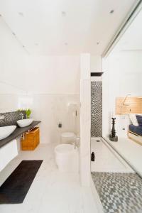 ein Badezimmer mit zwei Waschbecken, einer Badewanne und einem WC in der Unterkunft Suite Bacco Ortigia in Syrakus