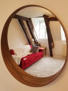 a mirror in a living room with a red couch at Best of Chartres one bedroom city center and view on the Cathedral in Chartres