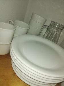 a stack of white plates and bowls on a table at Belgrano 360 in Tandil