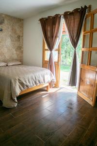 um quarto com uma cama e uma porta de vidro deslizante em Aldea Isla Sagrada em Cozumel